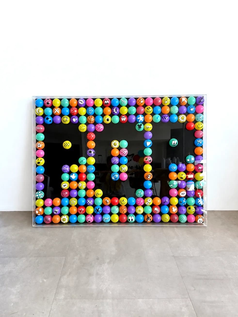 Canvas covered in a grid of colorful recycled ball-pit balls and post pens under clear acrylic, 90×120cm.